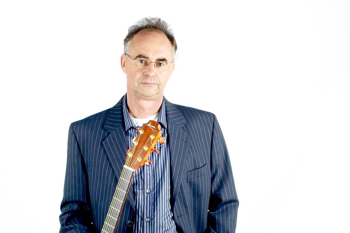 Steve Gifford standing with his guitar