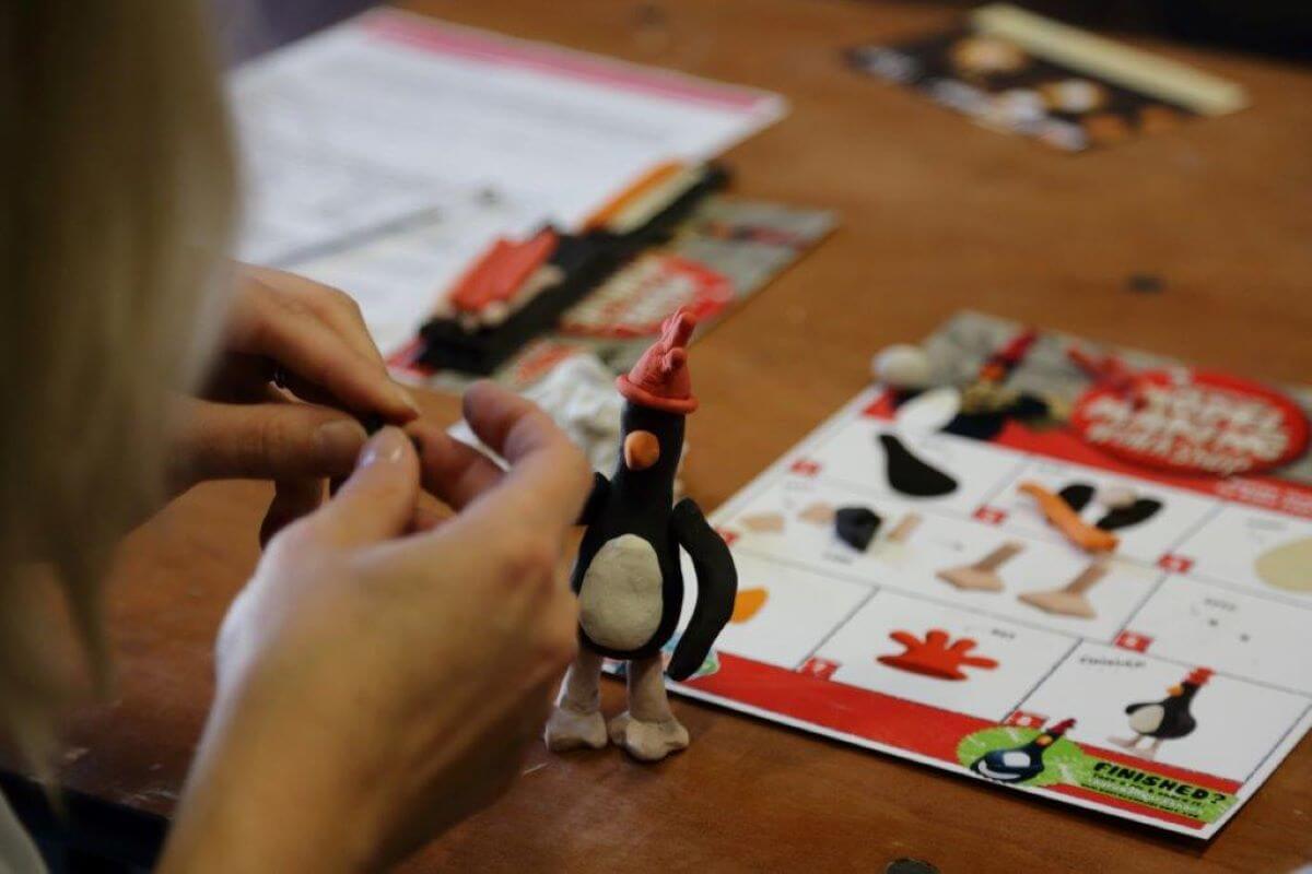 Hands making a model of an evil penguin