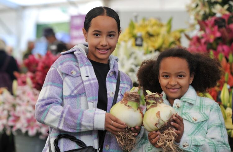 Two children hold giant onions