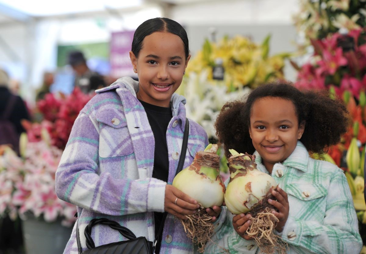 Two children hold giant onions