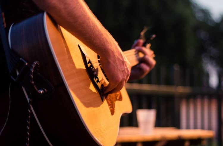 A person playing an acoustic guitar on stage