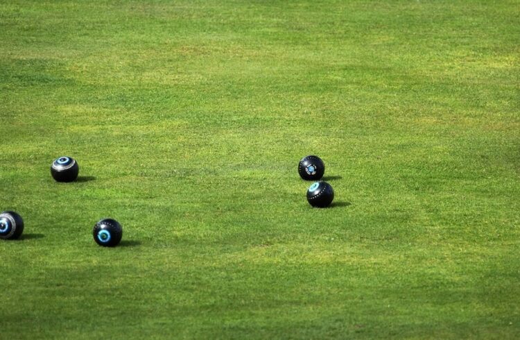 A game of bowls played on a vibrant green lawn