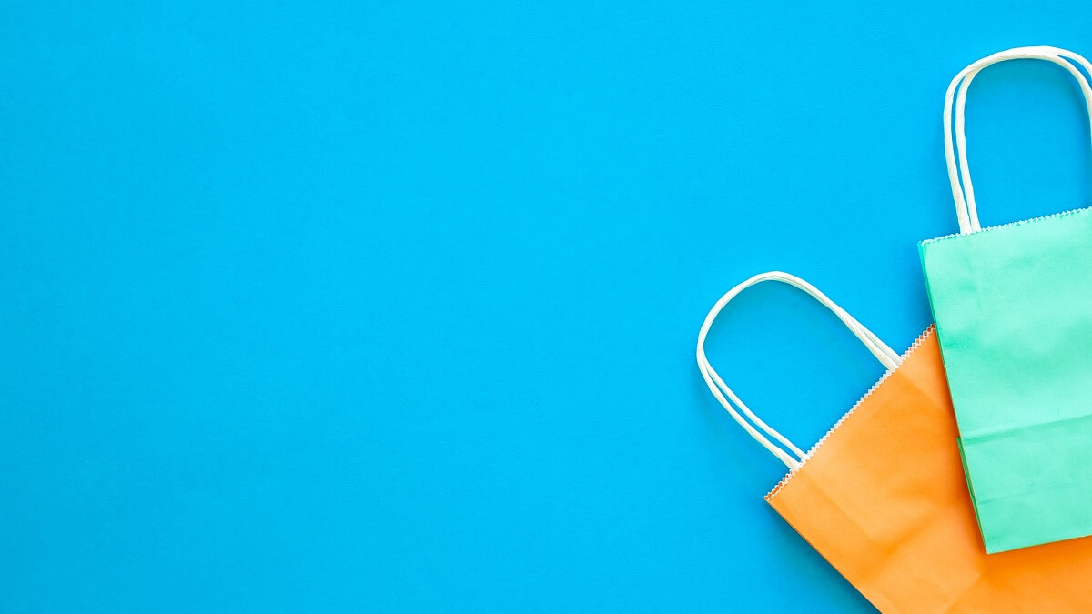 A green and an orange paper bag on a blue background