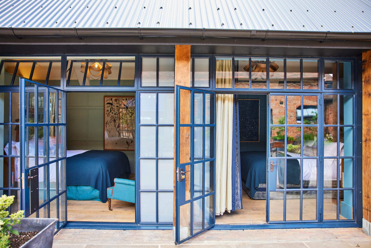 Black crittall windows looking into two courtyard bedrooms