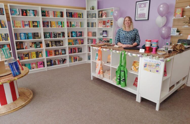 A bookshop with the owner standing behind the counter