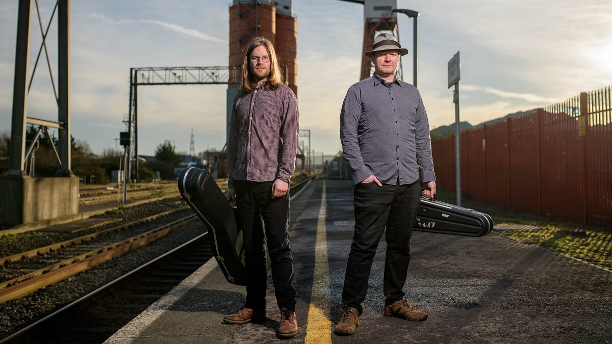 Kit and Aaron standing on a railway platform