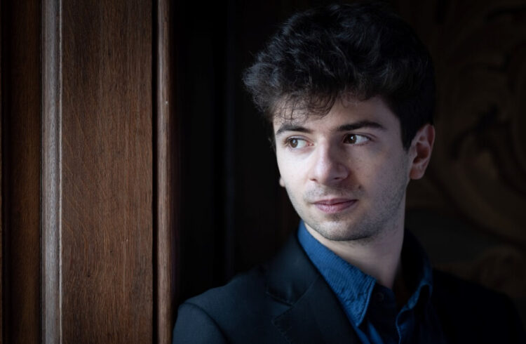 Musician Antoine Preat dressed in a blue shirt and black jacket