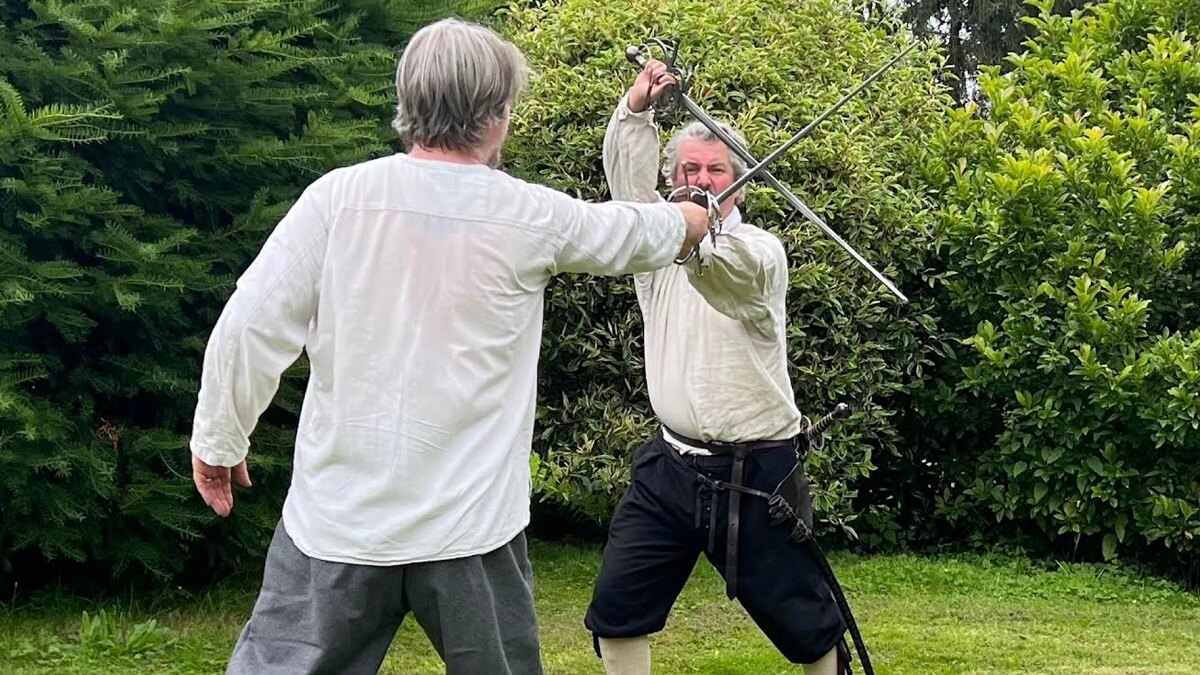 Two men practising fencing in period dress