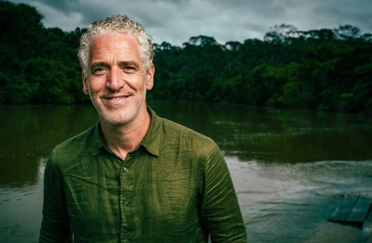 Gordon Buchanan dressed in a green shirt (background includes water and trees)