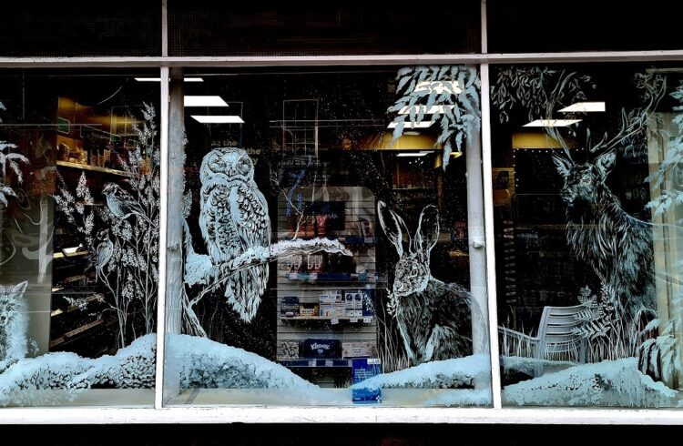 One of the designs on a shop window in Tenbury (includes hare, deer, owl, fox and plants)