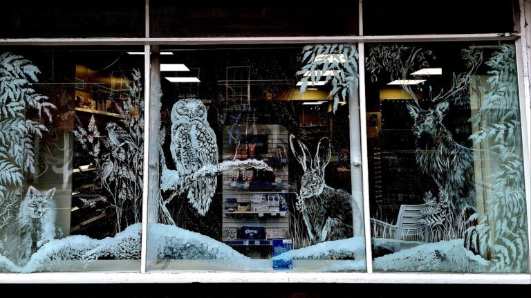 One of the designs on a shop window in Tenbury (includes hare, deer, owl, fox and plants)