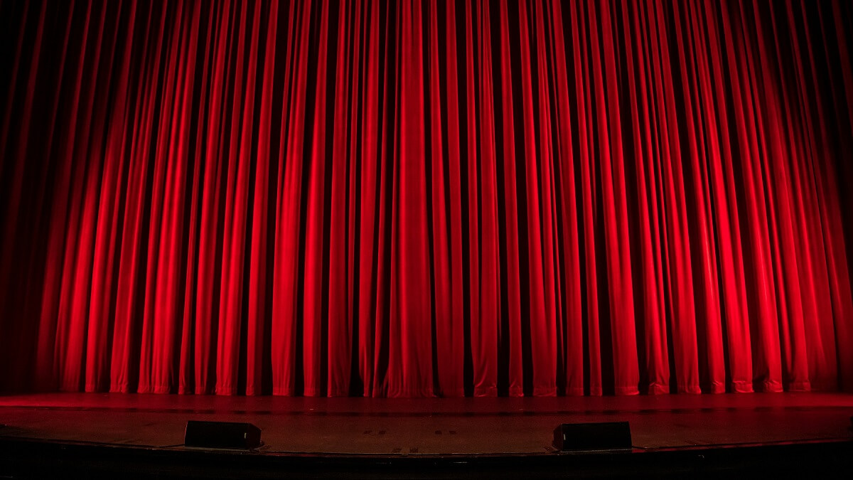 A red curtain across a theatre stage